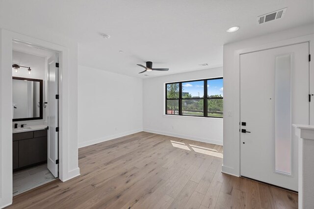 foyer entrance featuring ceiling fan and light wood-type flooring