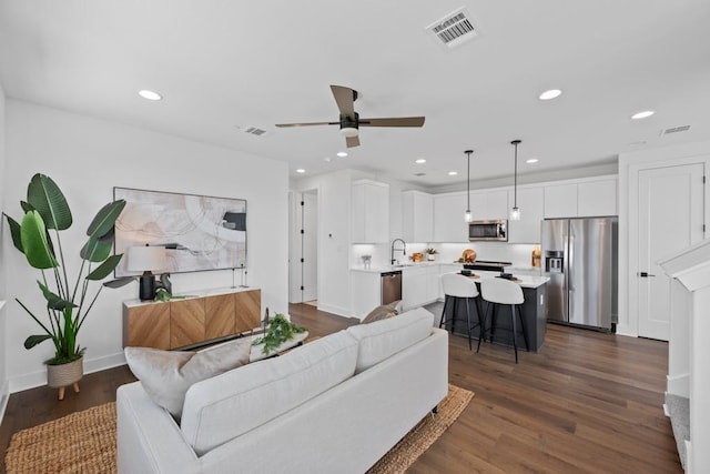 living room with ceiling fan, dark hardwood / wood-style flooring, and sink