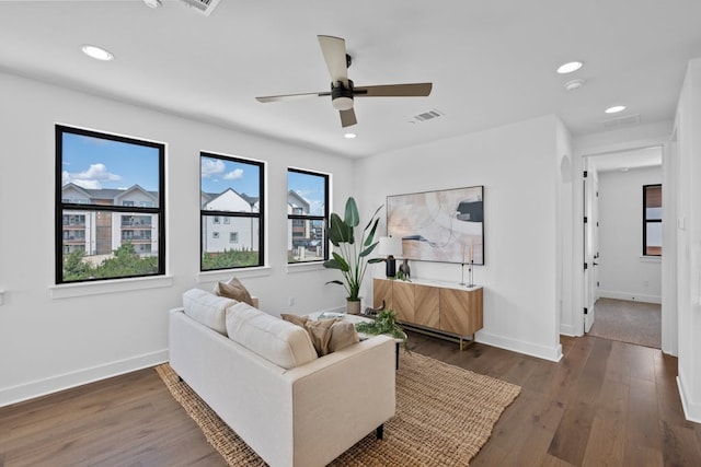 living room with dark hardwood / wood-style flooring, ceiling fan, and plenty of natural light