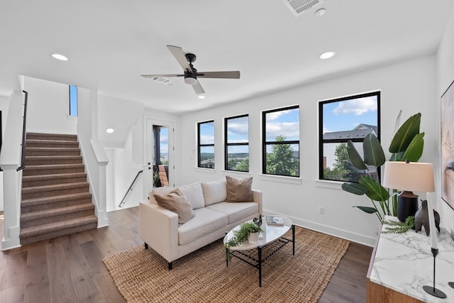 living room with ceiling fan and dark hardwood / wood-style flooring