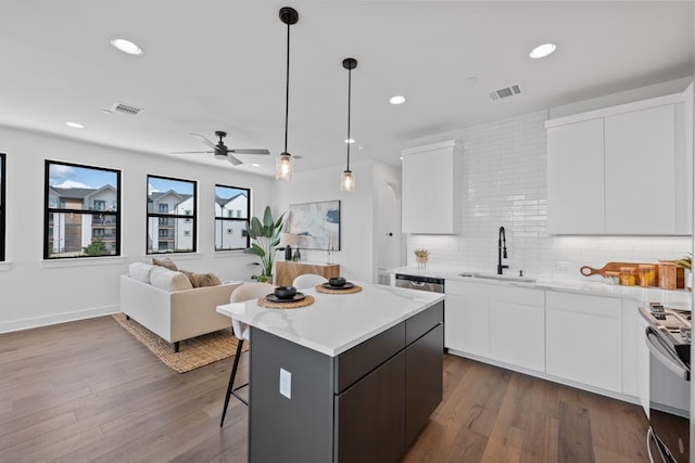 kitchen featuring white cabinets, sink, and hanging light fixtures