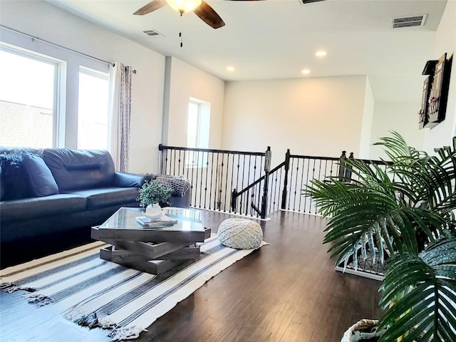 living room with ceiling fan and dark hardwood / wood-style flooring