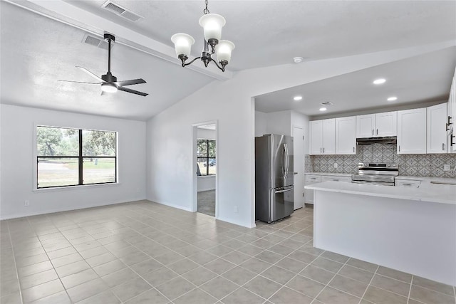 kitchen with vaulted ceiling with beams, pendant lighting, white cabinets, ceiling fan with notable chandelier, and appliances with stainless steel finishes