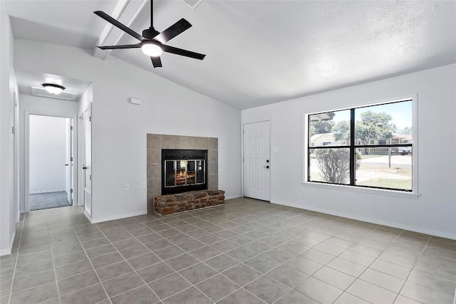 unfurnished living room featuring a fireplace, lofted ceiling with beams, ceiling fan, and light tile patterned flooring