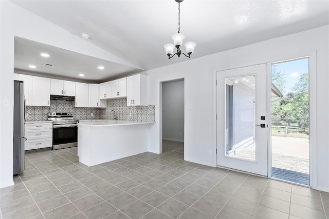 kitchen featuring stainless steel appliances, kitchen peninsula, decorative light fixtures, vaulted ceiling, and white cabinets