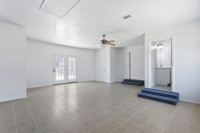 tiled spare room with ceiling fan and a textured ceiling