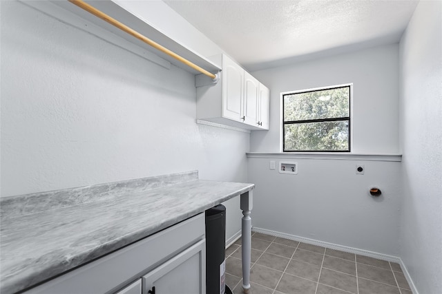 clothes washing area with cabinets, hookup for a washing machine, hookup for an electric dryer, and light tile patterned flooring