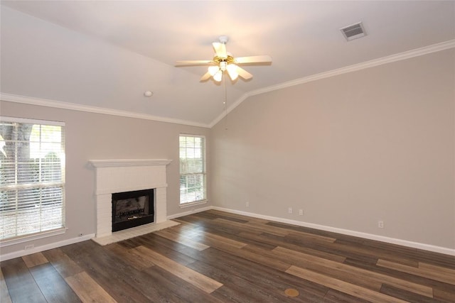 unfurnished living room with lofted ceiling, ceiling fan, dark hardwood / wood-style floors, ornamental molding, and a brick fireplace