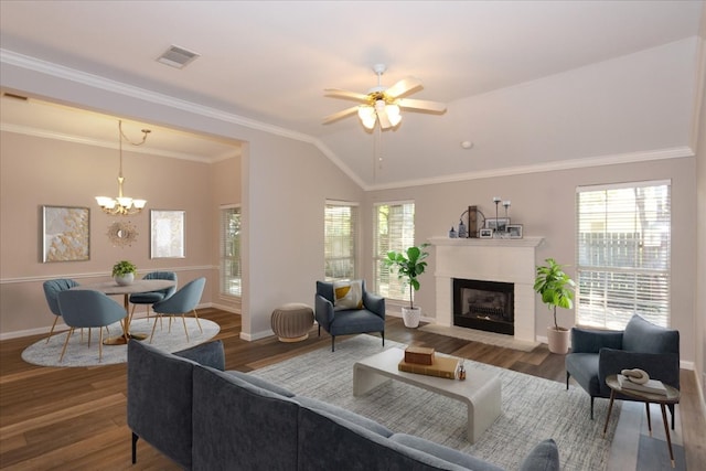 living room with crown molding, lofted ceiling, wood-type flooring, and a fireplace