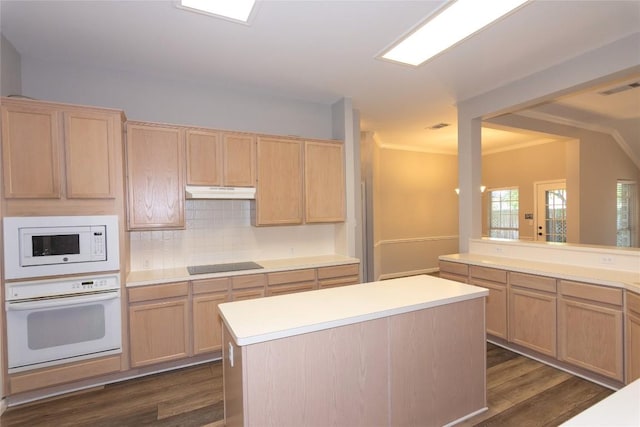 kitchen featuring white appliances, dark hardwood / wood-style flooring, a kitchen island, light brown cabinetry, and decorative backsplash