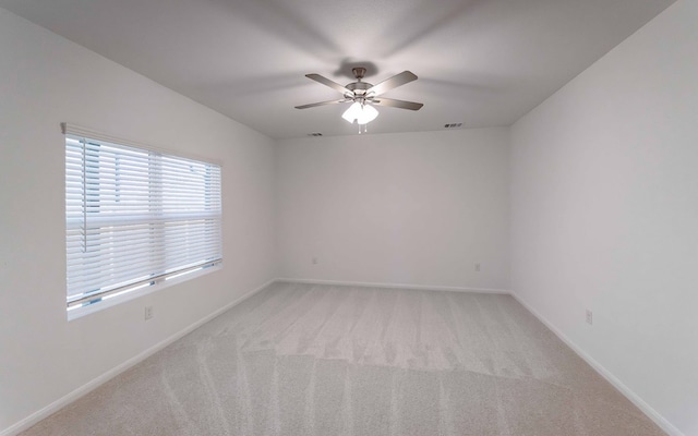 carpeted spare room featuring ceiling fan