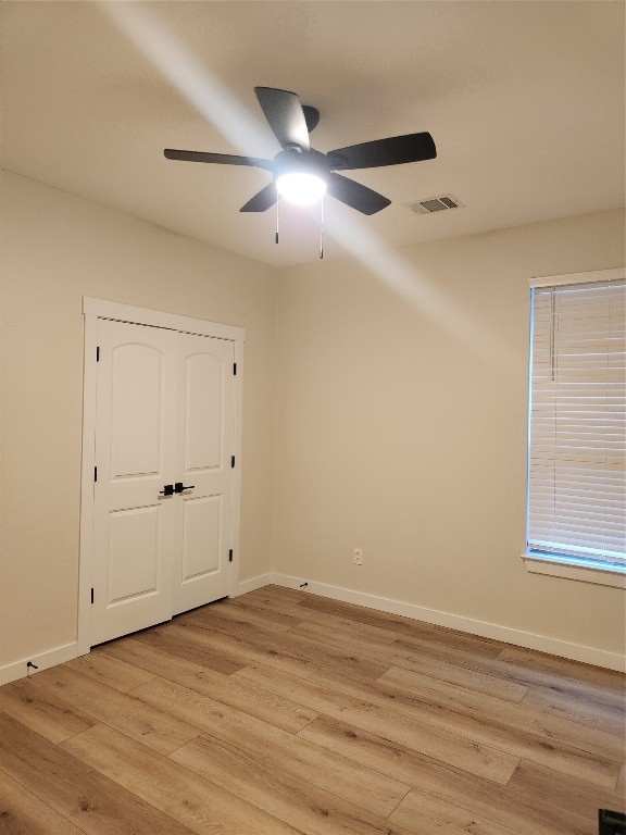 spare room featuring light hardwood / wood-style flooring and ceiling fan