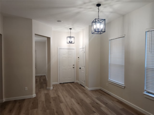 entryway with hardwood / wood-style floors and an inviting chandelier