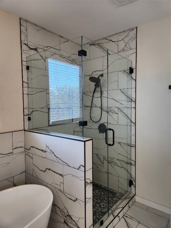 bathroom with separate shower and tub, tile patterned floors, and tile walls