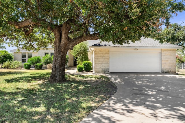 obstructed view of property with a garage and a front lawn