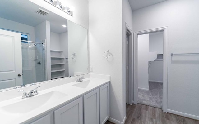 full bathroom with a stall shower, visible vents, a sink, and wood finished floors