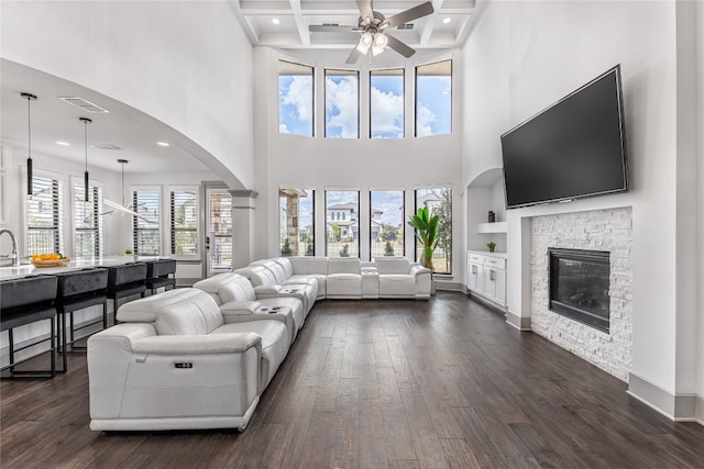 living room with a fireplace, dark hardwood / wood-style floors, built in features, beam ceiling, and coffered ceiling