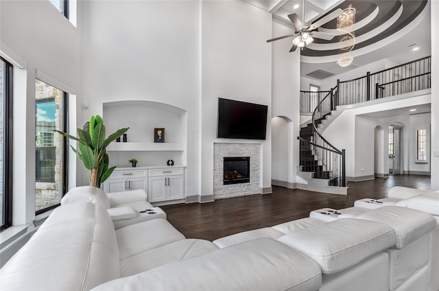 living room featuring a fireplace, plenty of natural light, and a high ceiling