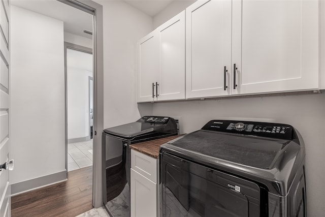 laundry room with washer and dryer, cabinets, and dark hardwood / wood-style floors