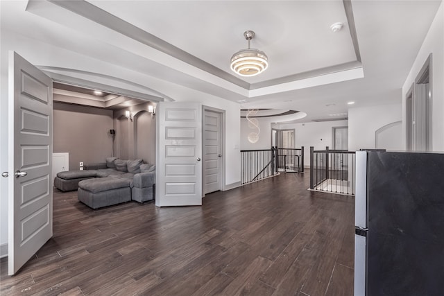 interior space with dark hardwood / wood-style floors and a raised ceiling