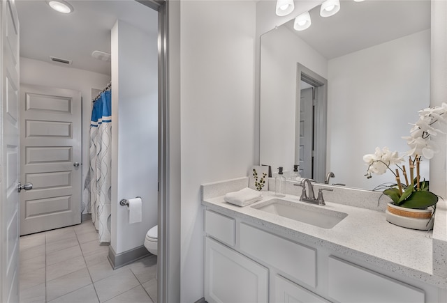 bathroom featuring toilet, tile patterned floors, and vanity