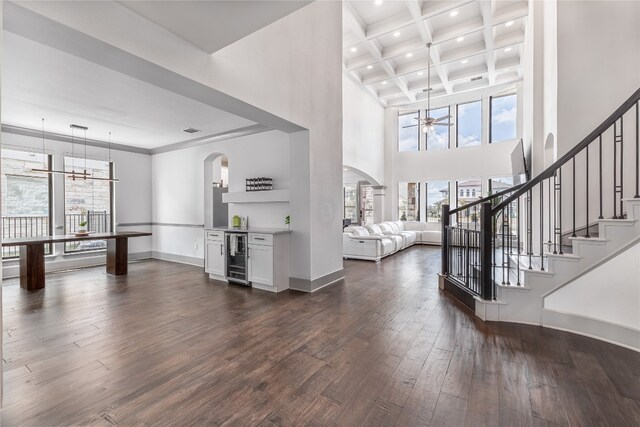 foyer featuring ceiling fan, dark wood-type flooring, beam ceiling, and coffered ceiling