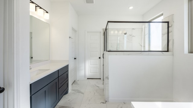 bathroom with a shower with door and vanity