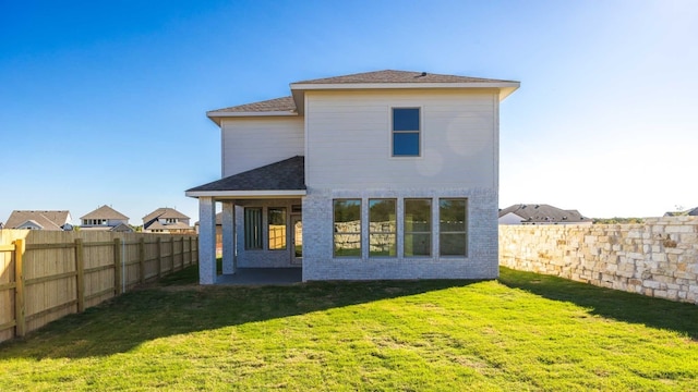 rear view of house with a patio and a yard