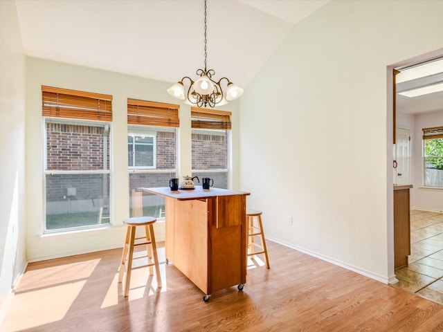 dining space featuring an inviting chandelier, light wood-type flooring, and lofted ceiling