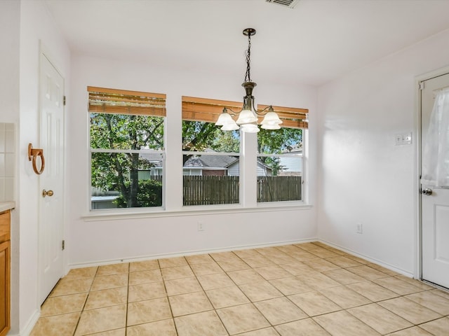 unfurnished dining area with a notable chandelier and light tile patterned floors