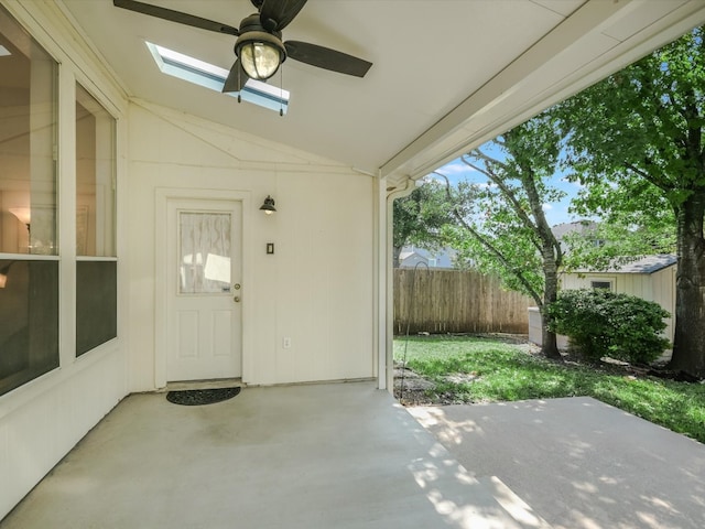 view of exterior entry featuring ceiling fan and a patio