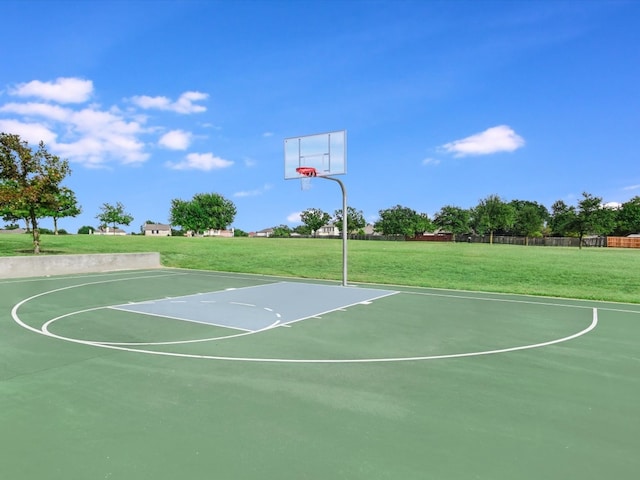 view of sport court with a lawn