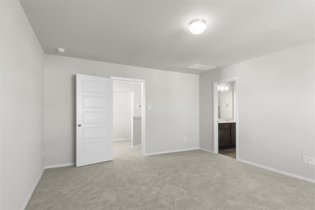 unfurnished bedroom with light colored carpet and ensuite bath