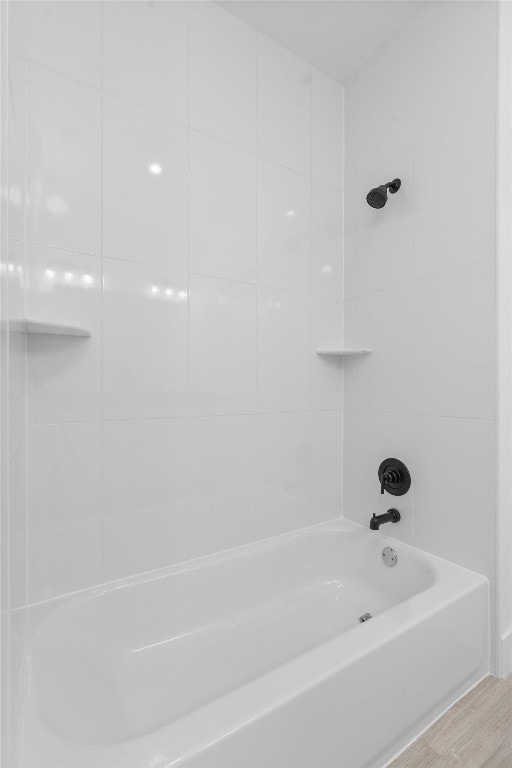 bathroom featuring tiled shower / bath combo and hardwood / wood-style flooring