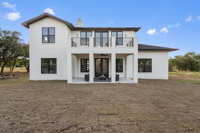 back of property with a balcony, ceiling fan, and a patio area