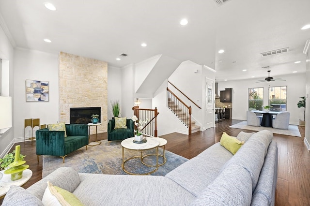 living room featuring a fireplace, ceiling fan, hardwood / wood-style floors, and ornamental molding