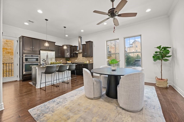 dining space with sink, ceiling fan, crown molding, and dark hardwood / wood-style floors