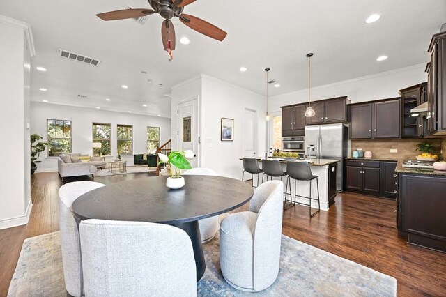 dining area featuring ceiling fan, dark hardwood / wood-style floors, and crown molding