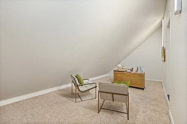 living area featuring vaulted ceiling and carpet floors