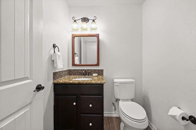 bathroom featuring vanity, hardwood / wood-style floors, and toilet