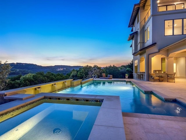 outdoor pool featuring a patio area, a mountain view, an outdoor bar, and an in ground hot tub