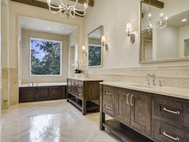 full bath with a healthy amount of sunlight, two vanities, a sink, and wainscoting