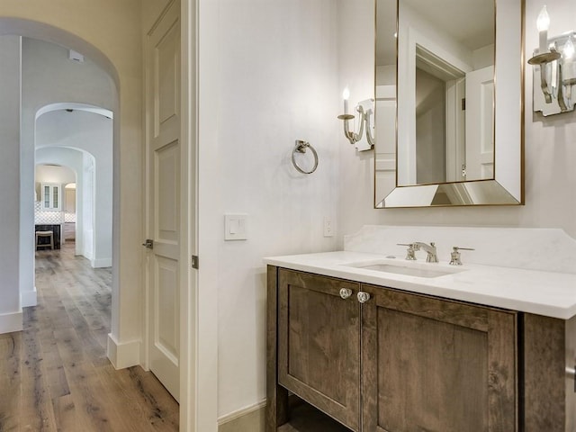 bathroom with wood finished floors, vanity, and baseboards