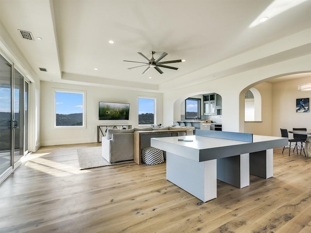 kitchen featuring visible vents, open floor plan, light countertops, a center island, and a raised ceiling