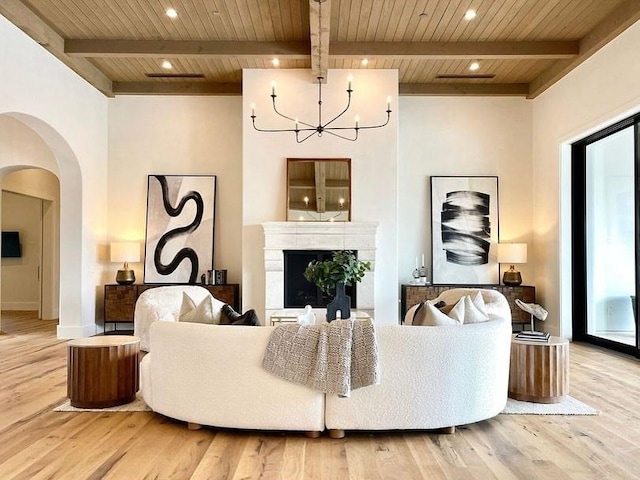 living room with arched walkways, wooden ceiling, and wood finished floors