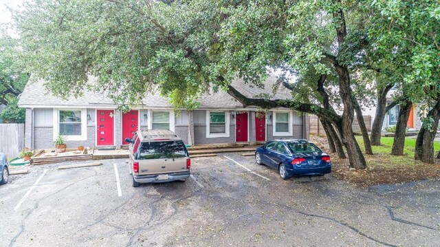 3465 Willowrun Dr, Austin, TX 78704 - view of front of house with brick siding, uncovered parking, and a shingled roof