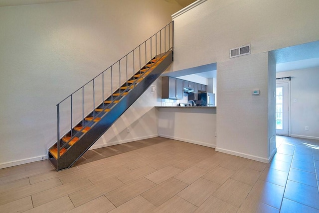 3465 Willowrun Dr, Austin, TX 78704 - staircase featuring baseboards and a towering ceiling