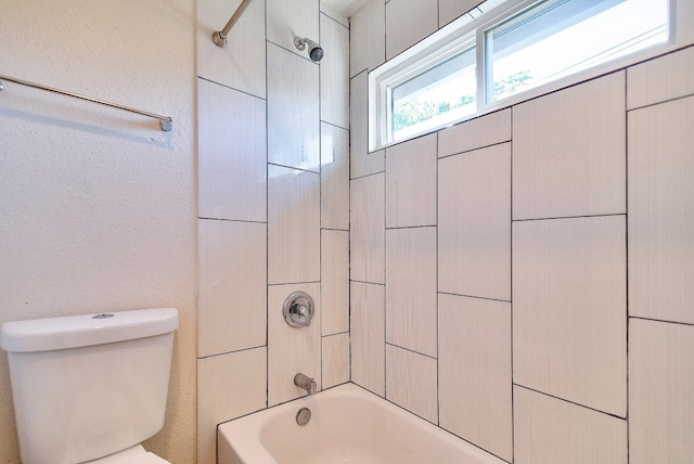 bathroom with tiled shower / bath and toilet