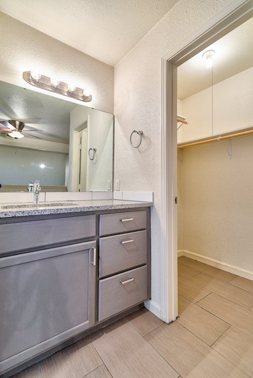 bathroom featuring a textured ceiling, ceiling fan, vanity, and tile patterned floors