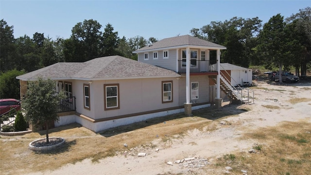 view of front of home featuring roof with shingles, stairway, and crawl space